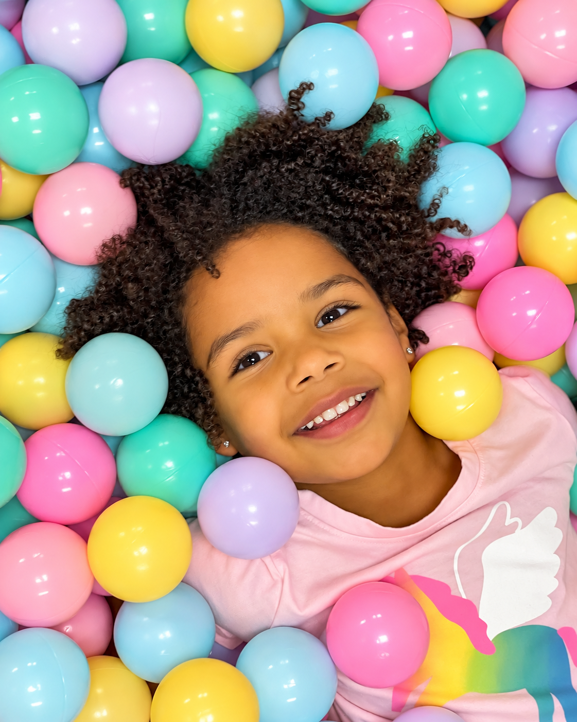 Girl smiling in a pastel ball pit